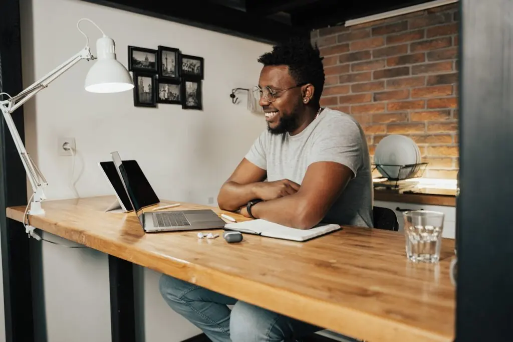Smiling man working at a laptop in a bright home office